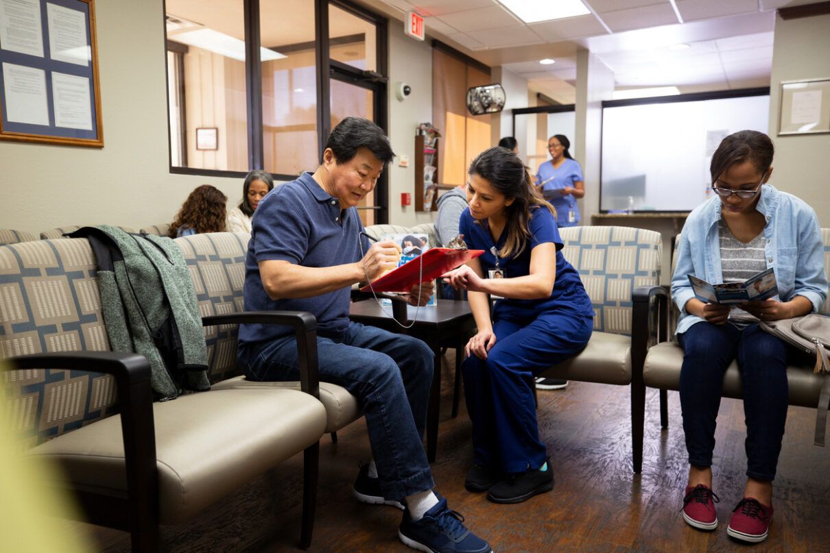 Mid adult nurse helps a senior man fill out a medical form after a missed diagnosis