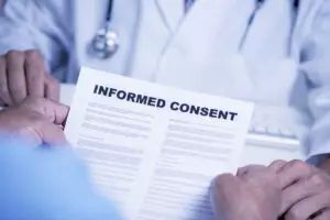 Male patient reviewing an informed consent contract with his doctor.