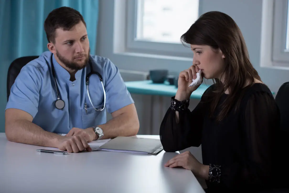 a doctor explaining medical mistakes made to a woman.