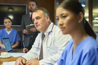 medical team hear presentations from lawyers in the hospital board room to discuss medical malpractice cases